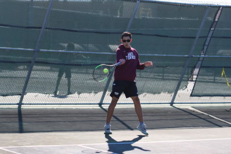 Daniel forehands a tennis  ball towards his competitor during his 7th period Tennis class. 