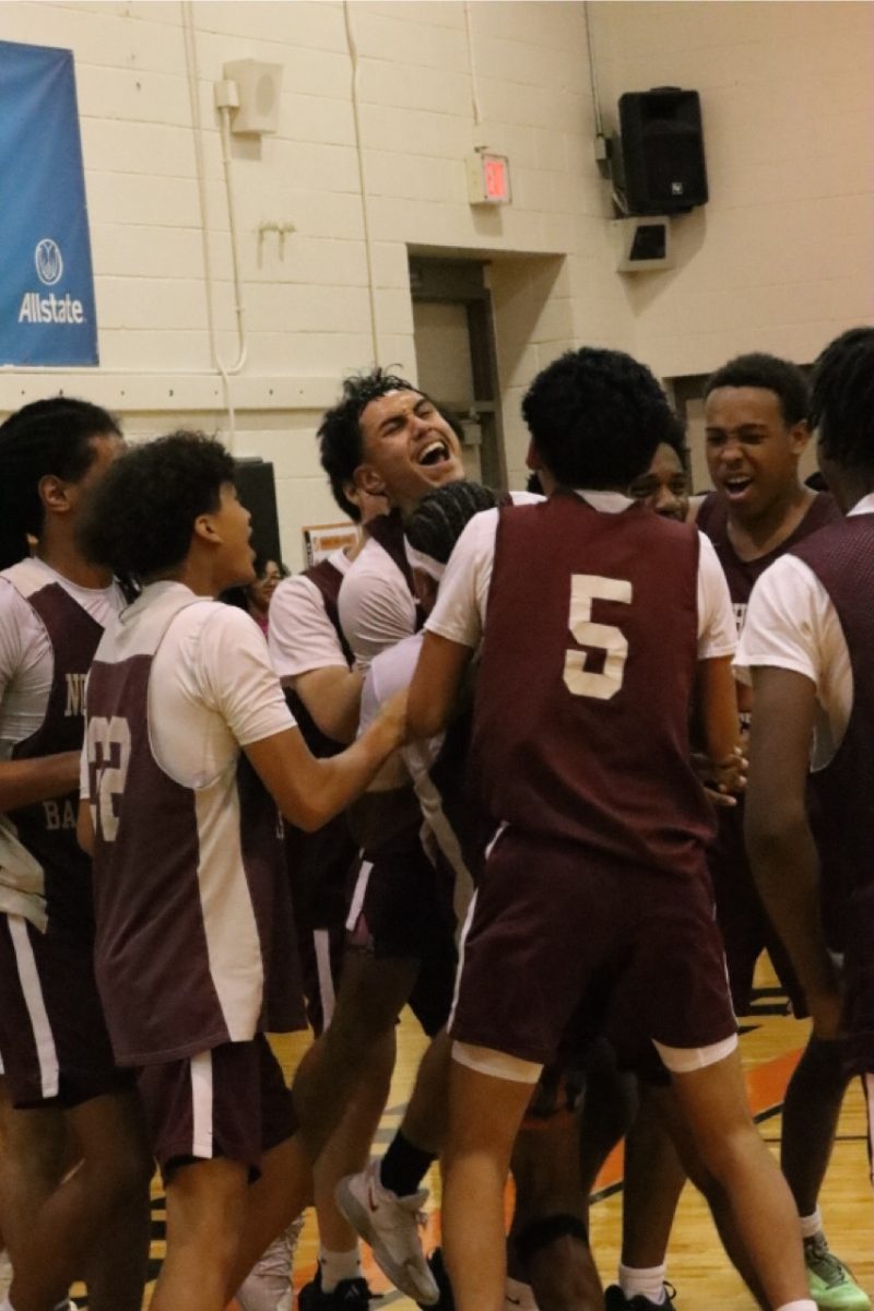 The boys basketball team celebrates after Terrell Woodward